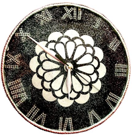 Artistic Design & Craftsmanship Kolam-Inspired Mandala Pattern: The heart of this clock features a sacred geometric floral motif, symbolizing balance, unity, and positive energy. Luxury Black & White Contrast: The bold jet-black resin base paired with shimmering white mandala details creates a striking, high-end look. Crystal Studded Roman Numerals: Each numeral is designed with embedded shimmering stones, offering sparkle and a regal touch. Intricate Resin Detailing: Hand-poured resin with precision artistry ensures a smooth glossy finish that enhances the luxurious aesthetic.