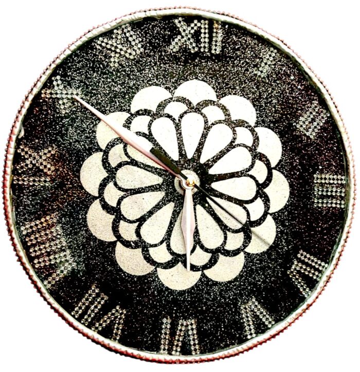Artistic Design & Craftsmanship Kolam-Inspired Mandala Pattern: The heart of this clock features a sacred geometric floral motif, symbolizing balance, unity, and positive energy. Luxury Black & White Contrast: The bold jet-black resin base paired with shimmering white mandala details creates a striking, high-end look. Crystal Studded Roman Numerals: Each numeral is designed with embedded shimmering stones, offering sparkle and a regal touch. Intricate Resin Detailing: Hand-poured resin with precision artistry ensures a smooth glossy finish that enhances the luxurious aesthetic.